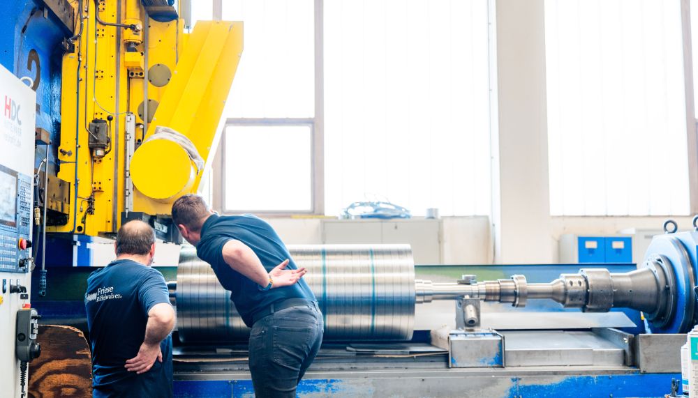 Mitarbeiter der Friese GmbH bei der Profilkontrolle an einer Riffelwalze